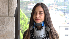 The last thing Clara remembers before the explosion was taking a picture of the smoke with her phone. Clara is pictured wearing a black shirt and has neck brace and a bruised face from her injuries from the explosion. Photo by Firas Atani for Project HOPE, 2020.