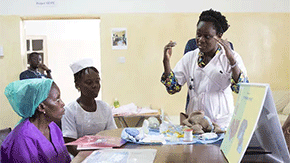 A doctor speaks to health workers in a maternal ward about how to use kangaroo wraps and help more babies thrive.