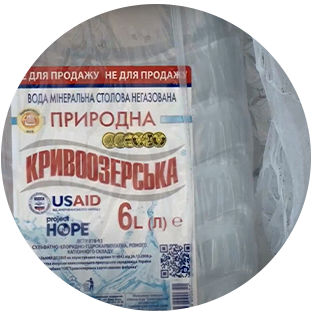 A round closeup photograph of a 6-liter bottle of water and its label. The label is written in Ukrainian and has the Project HOPE logo.