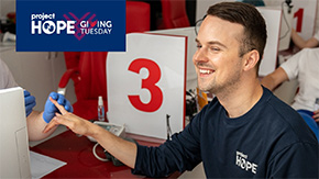 A photograph of a Project HOPE team member smiling as he gives a donation of blood in Ukraine.