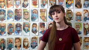 Julia Maddalina stands in front of portraits of health workers she's painted in their honor