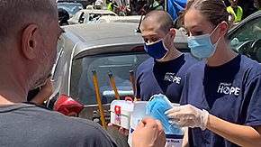 Two Project HOPE health workers hand out protective masks in Beirut