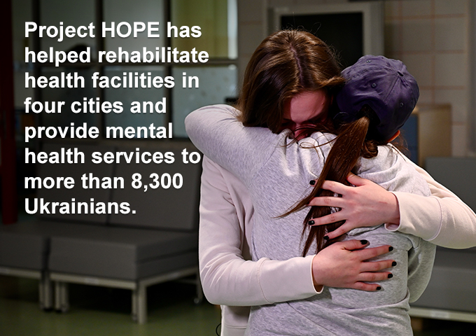 Two people embracing. Text overlay: Project HOPE has helped rehabilitate health facilities in four cities and provide mental health services to more than 8,300 Ukrainians.