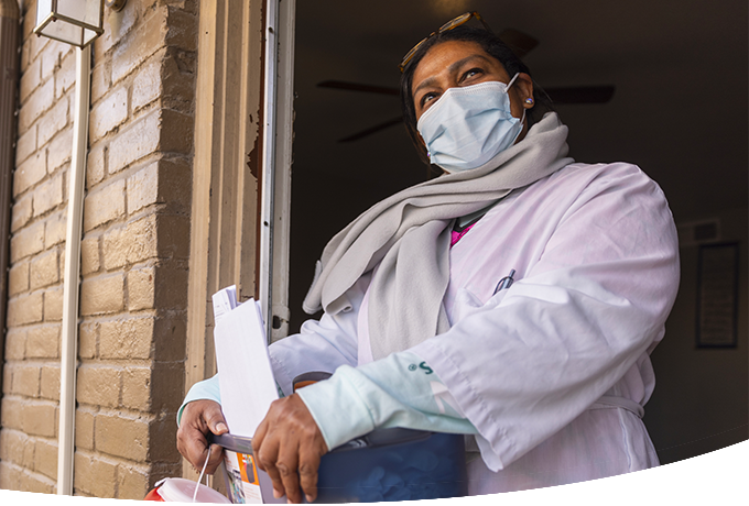 Health worker in mask exiting a door