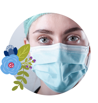 A nurse is pictured up close. She is wearing a mask and surgical cap as she makes sincere eye contact