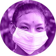 A photograph in the shape of a circle shows a young girl in India smiling at the camera with her eyes. She is wearing a white medical mask that covers her nose and mouth. The photo has a bright purple toned overlay.