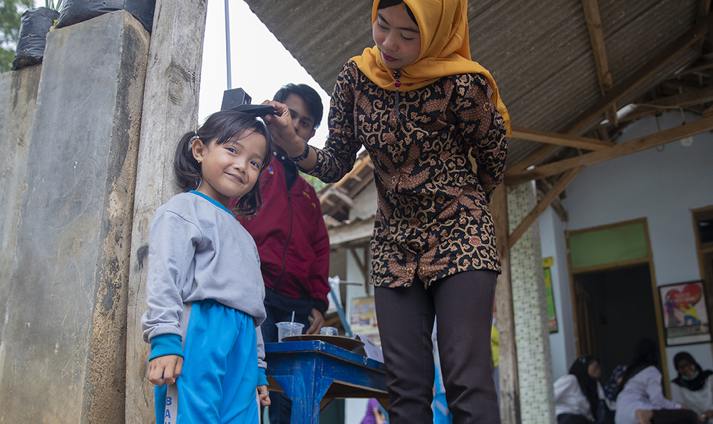 Volunteers record the growth of children to track their health.