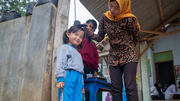 A child in Indonesia gets a check-up at a free health fair