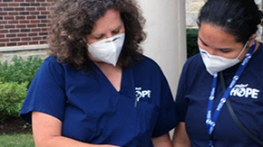 Two Project HOPE nurses confer outside